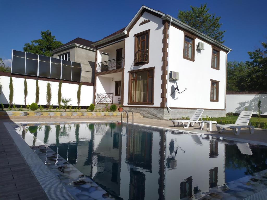 a house with a swimming pool in front of a house at Qafqaz Panoramic Mountain Chalet in Gabala