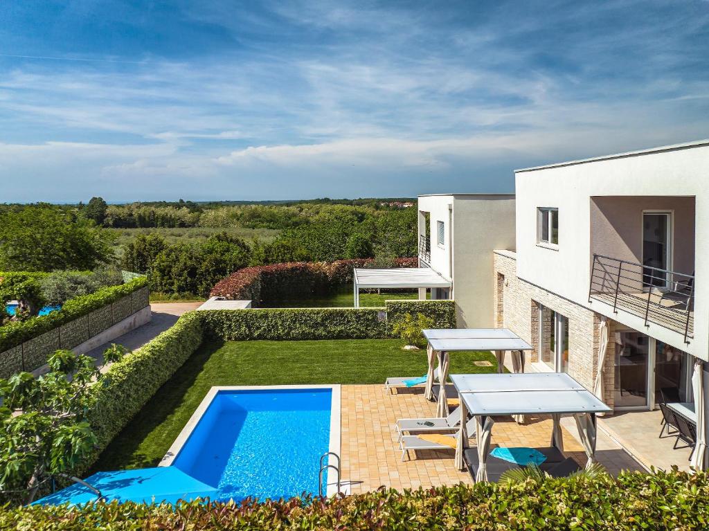 une cour arrière avec une piscine, une table et des chaises dans l'établissement Villa Sky Dream, à Novigrad
