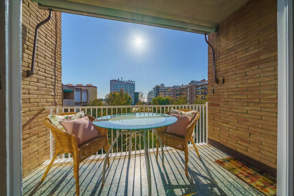 a balcony with a glass table and two chairs at HomeHolidaysRentals Miracel - Costa Barcelona in Malgrat de Mar