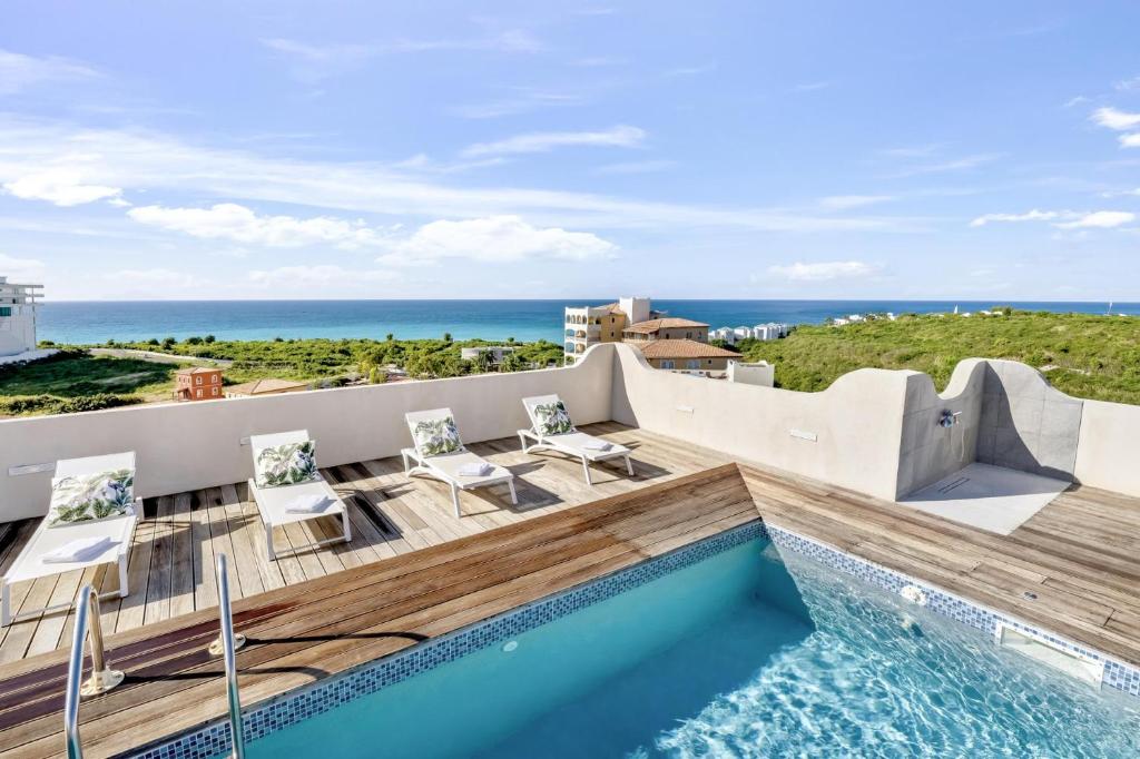 a view of the ocean from a house with a swimming pool at Fine 3 BR Oceanview Penthouse in Prime Location - La Perla Sky in Cupecoy