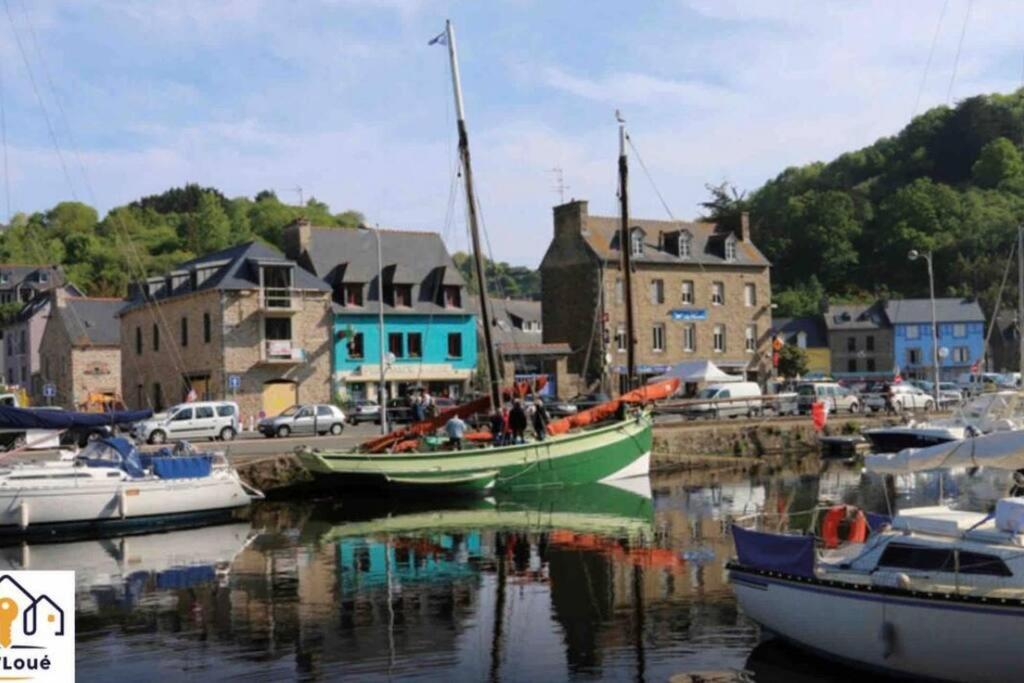 una barca verde è ormeggiata in un porto con edifici di Paul Bert Seh’Loué a Saint-Brieuc