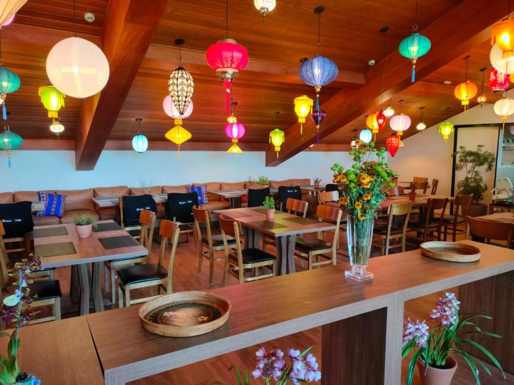 un restaurant avec des tables, des chaises et des lumières colorées dans l'établissement Wanderlust Experience Hotel, à Campos do Jordão