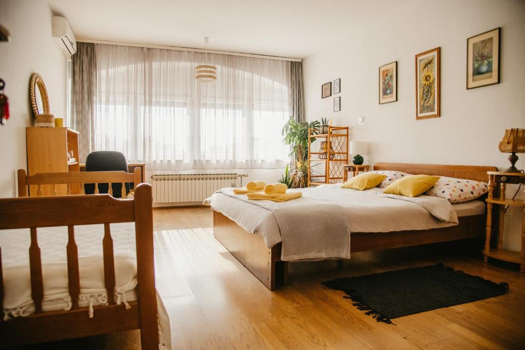 a bedroom with a large bed and a large window at Soba Gloria in Slavonski Brod