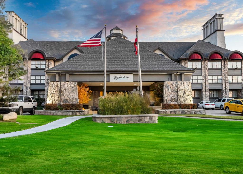 un hotel con una bandera americana delante de él en Radisson Salt Lake Airport en Salt Lake City