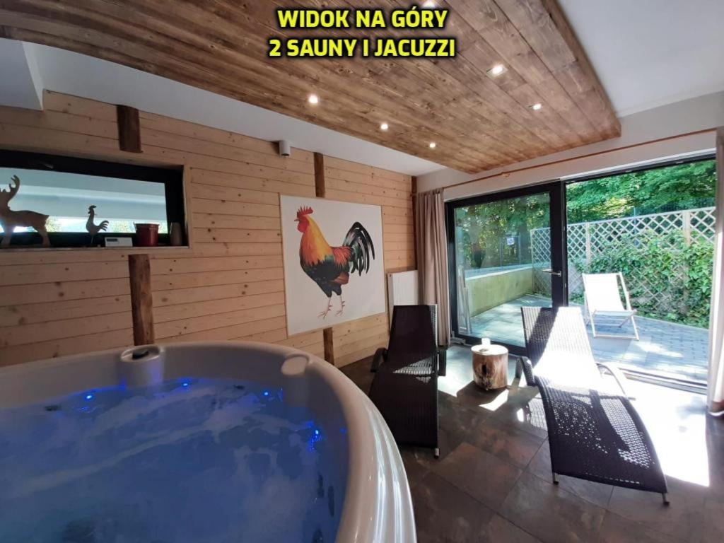 uma banheira num quarto com uma galinha na parede em Wellness Apartamenty Złoty Widok em Szczyrk