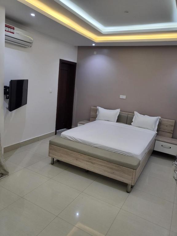 - une chambre avec un lit et une télévision à écran plat dans l'établissement Appartement à couper de souffle, à Dakar