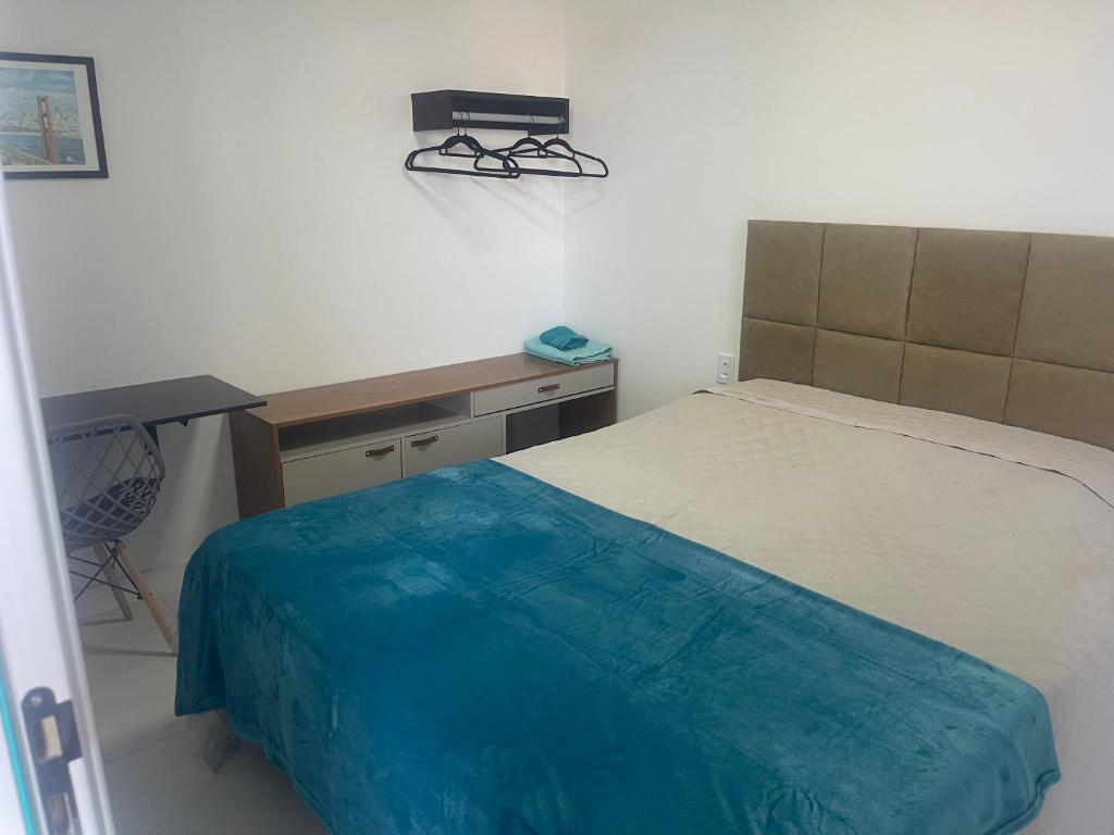 a small bedroom with a bed and a desk at Acquarius Residence Vista Mar in Fortaleza