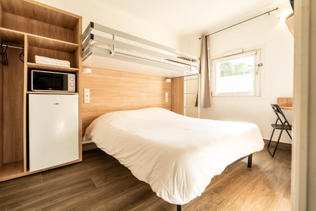 a small bedroom with a bed and a window at My KB H&ocirc;tel Mont&eacute;limar in Saulce-sur-Rh&ocirc;ne