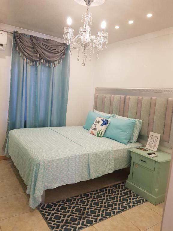 a bedroom with a bed and a chandelier at The Santy's in Oranjestad