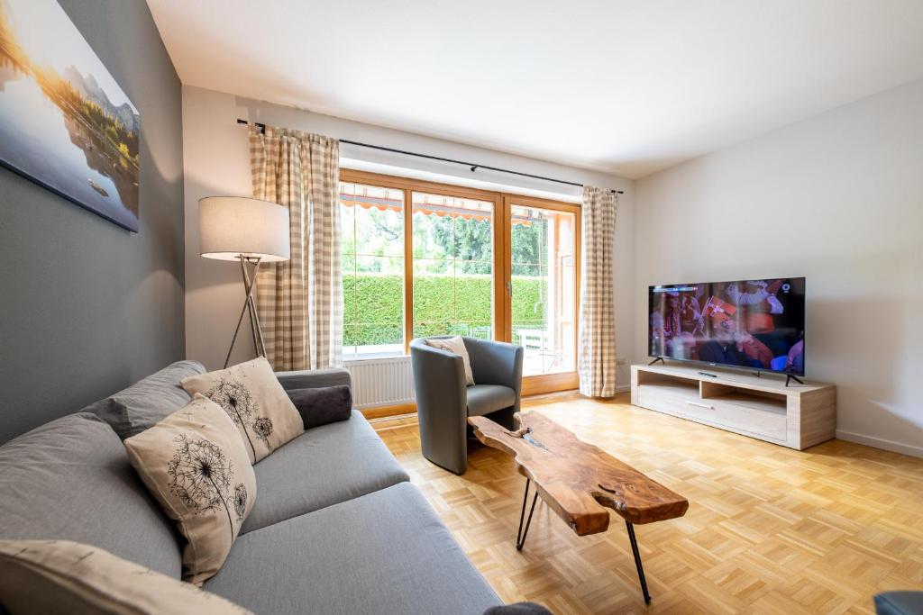 a living room with a couch and a tv at Mittendrin in Garmisch-Partenkirchen