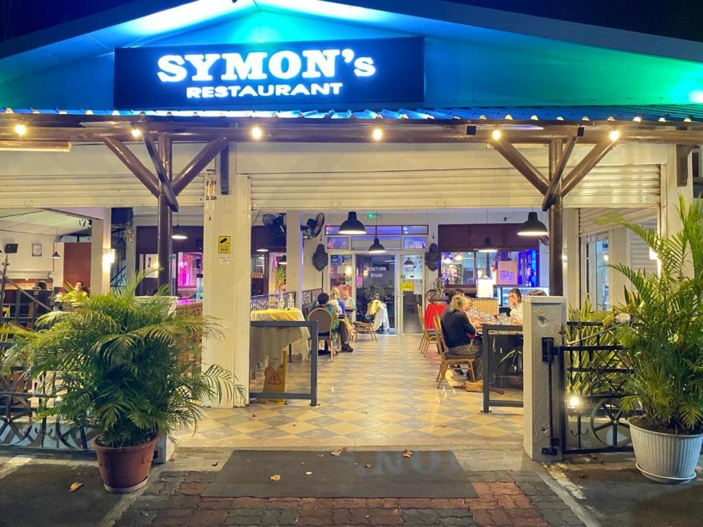 a restaurant with people sitting inside of it at night at Symon Belle Mare Lodge in Belle Mare