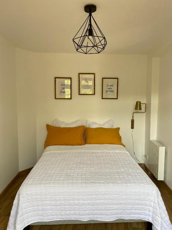 a bedroom with a large white bed with orange pillows at Magnifique appartement 2&#47;4 pers - Le Saint Leo in Saint-Léonard-des-Bois