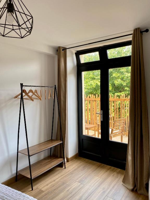 a bedroom with a black door and a window at Magnifique appartement 2&#47;4 pers - Le Saint Leo in Saint-Léonard-des-Bois