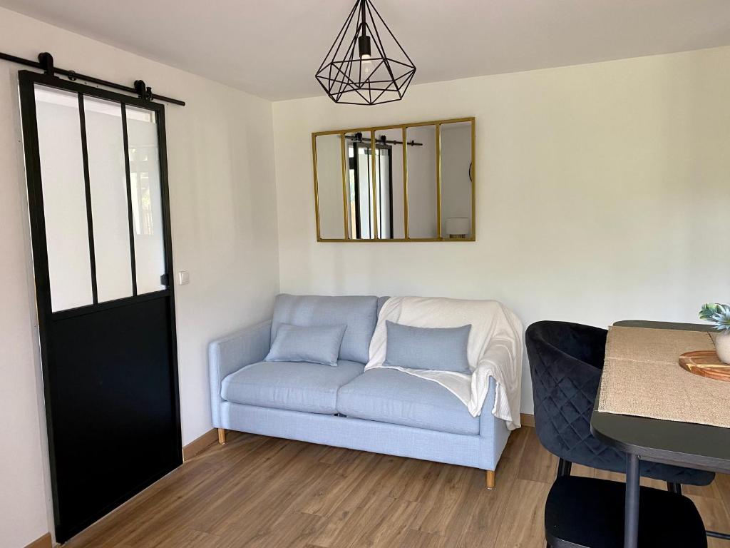 a living room with a couch and a mirror at Magnifique appartement 2&#47;4 pers - Le Saint Leo in Saint-Léonard-des-Bois