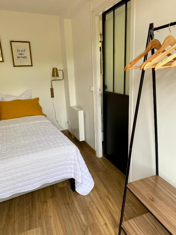 a bedroom with a white bed and a wooden floor at Magnifique appartement 2&#47;4 pers - Le Saint Leo in Saint-Léonard-des-Bois