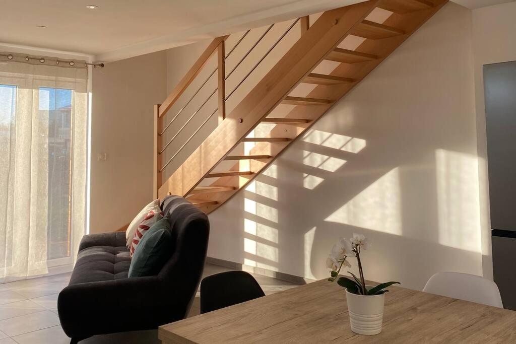eine Person, die in einem Wohnzimmer mit einer Treppe auf einem Stuhl sitzt in der Unterkunft Appartement dans une grange rénovée in Straßburg