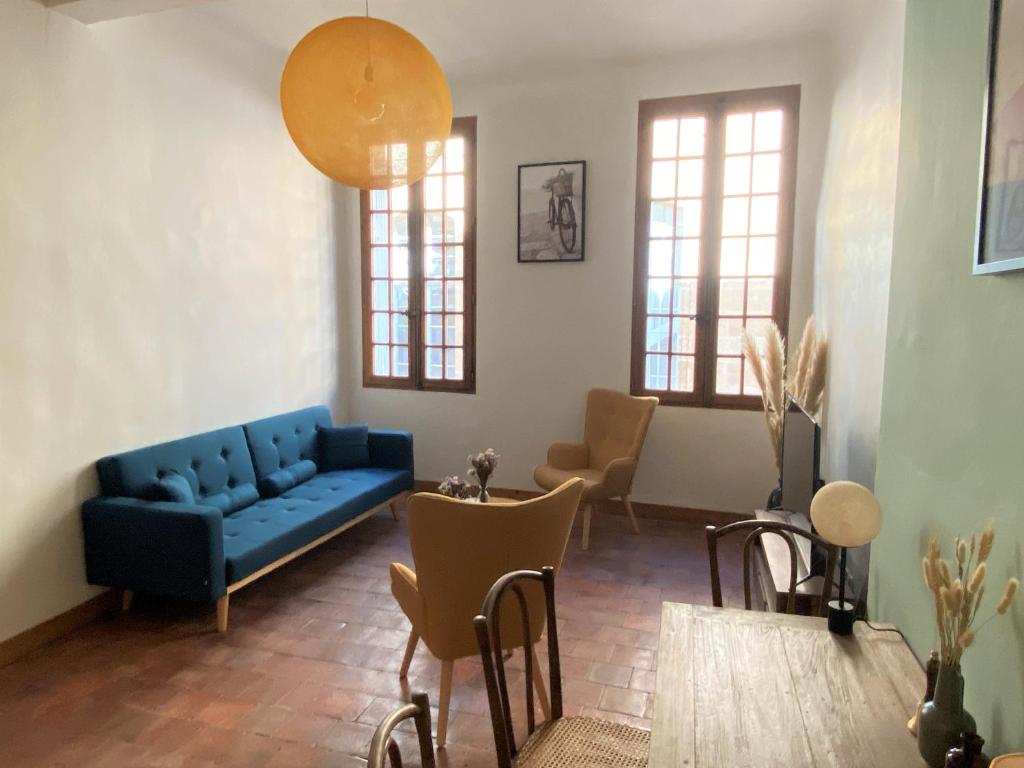 Studio Mezzanine Mairie في آكس أون بروفانس: غرفة معيشة مع أريكة وكراسي زرقاء