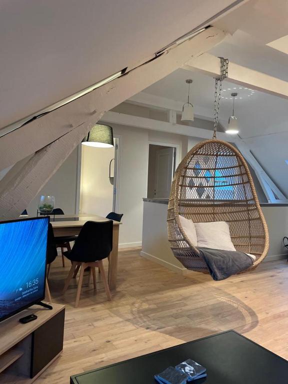 - un salon avec une chaise suspendue et une table dans l'établissement LE COCON : 2 chambres - Centre-ville, à Bourges