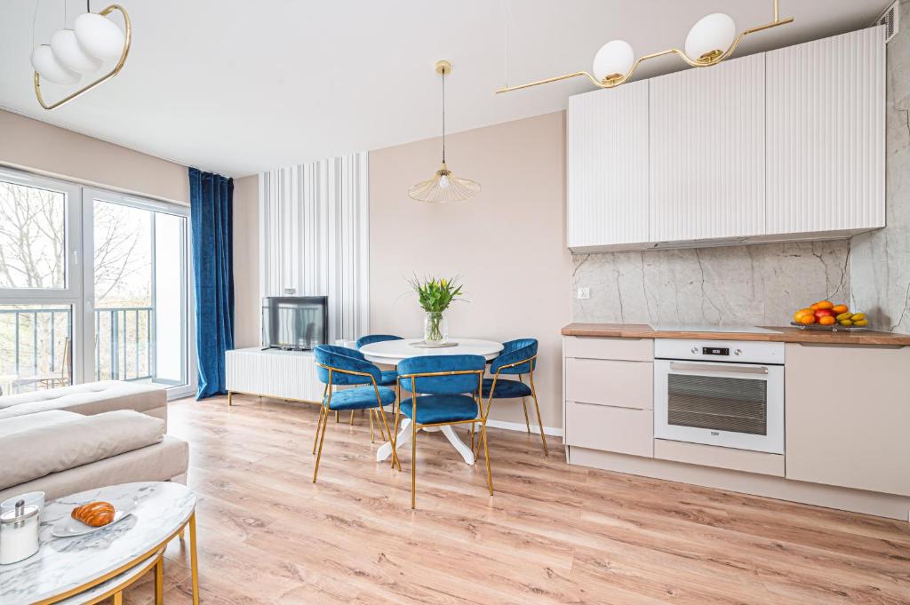 uma cozinha e sala de estar com mesa e cadeiras em Nova Letnica - BillBerry Apartments em Gdansk