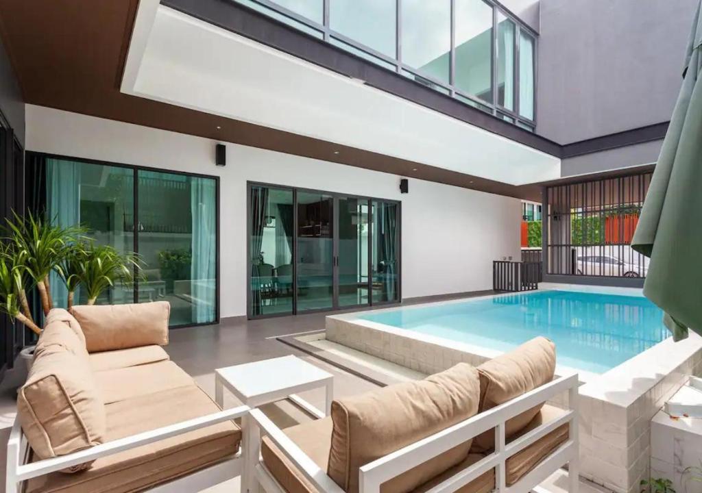 uma sala de estar com piscina e uma casa em Astro Deluxe 4 Bedrooms Villa em Nong Prue