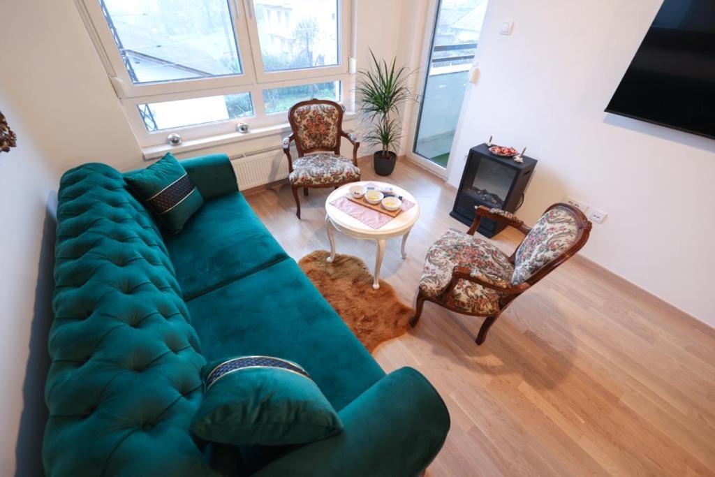 a living room with a green couch and chairs at Apartman MRL Cavic in Banja Luka