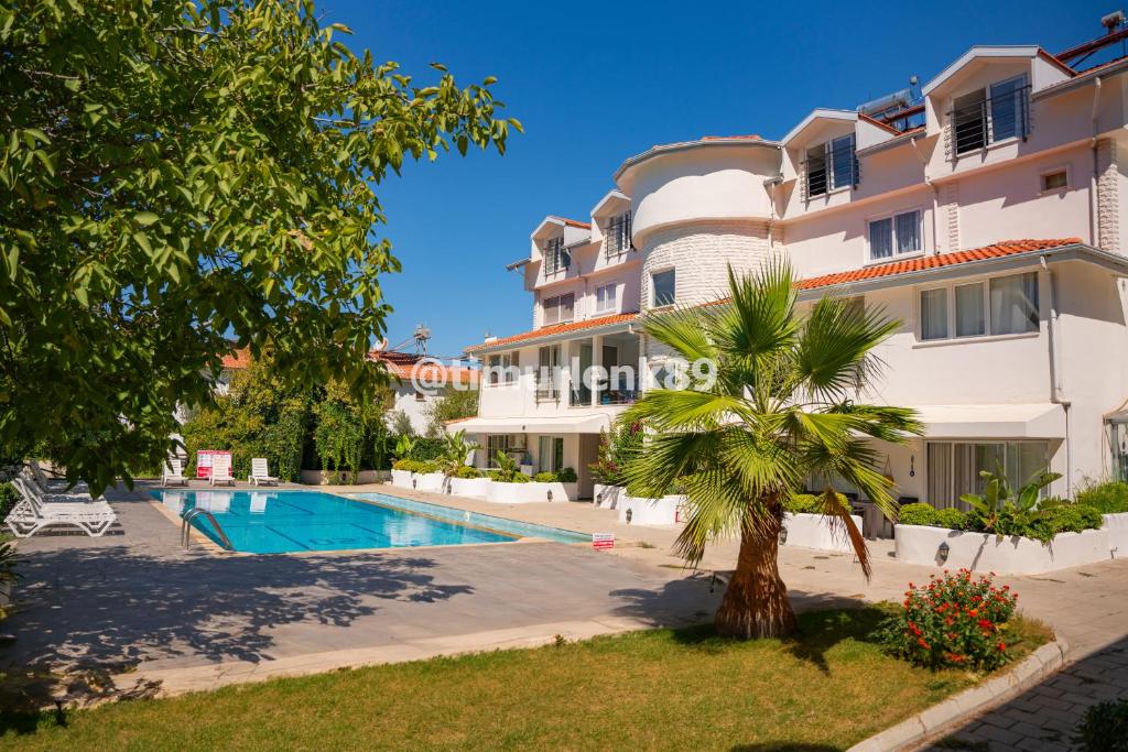 een groot appartementencomplex met een zwembad en een palmboom bij Stunning Suite in Ölüdeniz with Seaview And Pool in Oludeniz