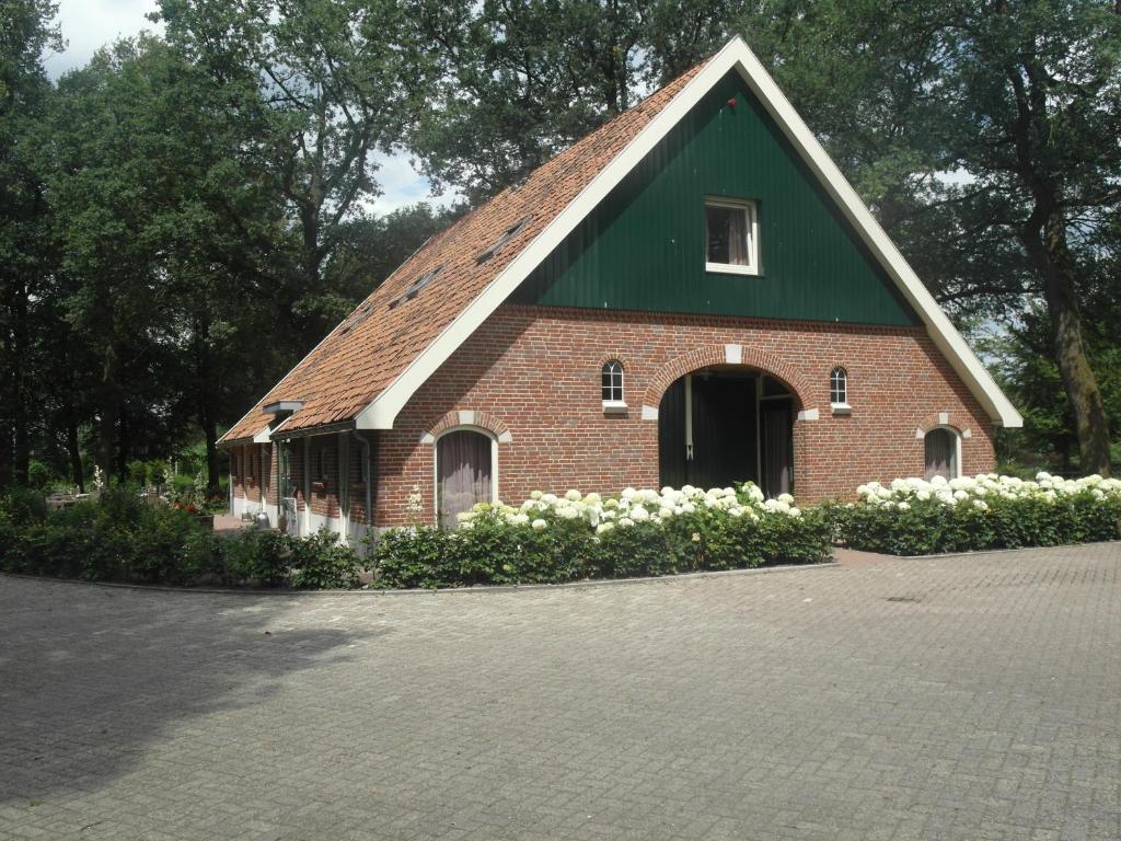 een rode bakstenen kerk met witte bloemen ervoor bij B&B De Pepper in Haaksbergen