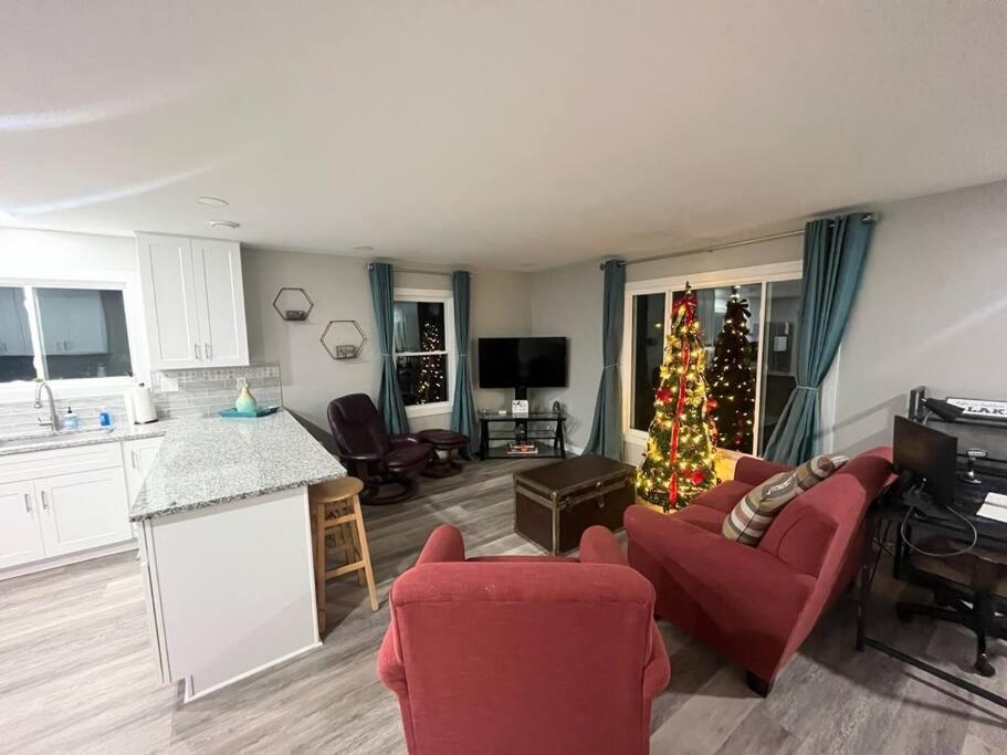 ein Wohnzimmer mit einem Weihnachtsbaum und eine Küche in der Unterkunft Harbor Haven: Stay, Sail, Dine! 