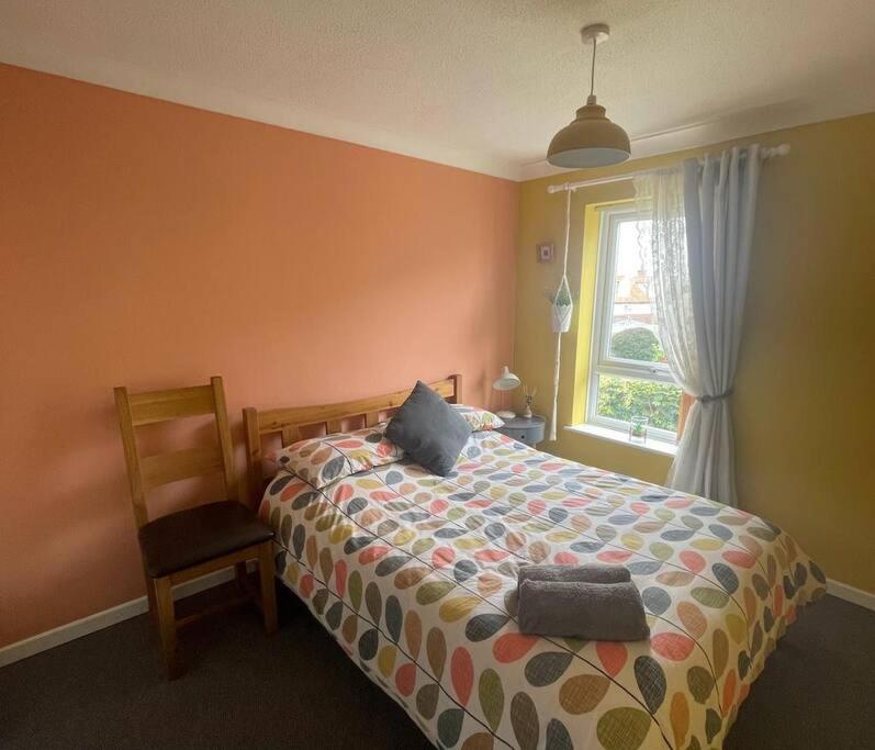 a bedroom with a bed with a chair and a window at Waterside Villa in Corton