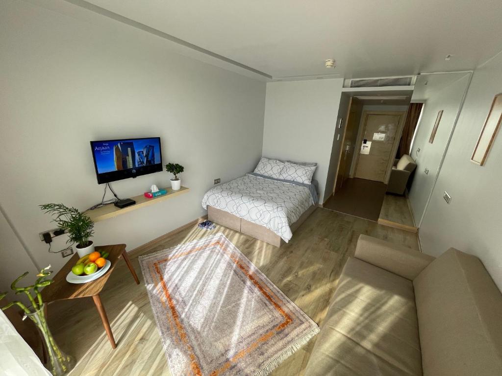 Habitación pequeña con cama y TV. en studio unit whit pool and gym, en Estambul