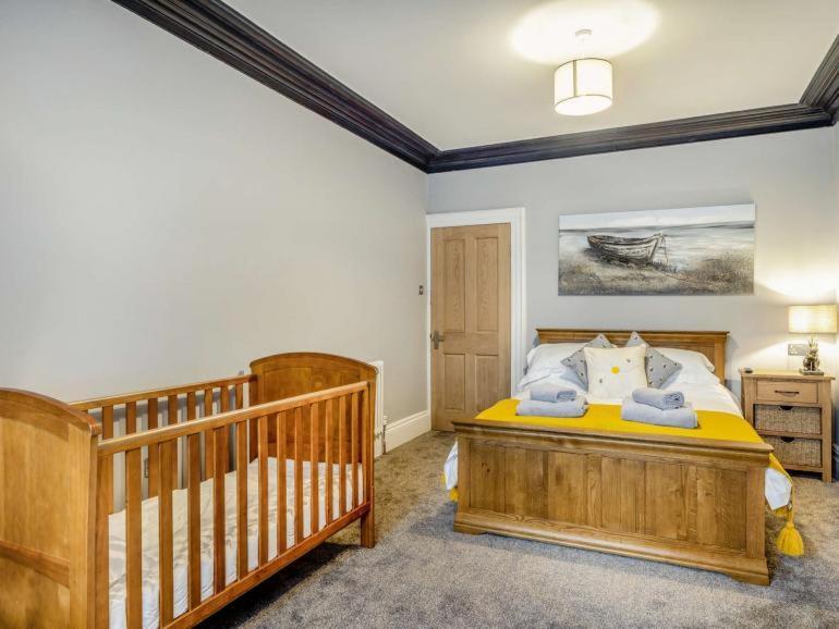 a bedroom with two cribs and a bed in it at Ashley Place in Southport