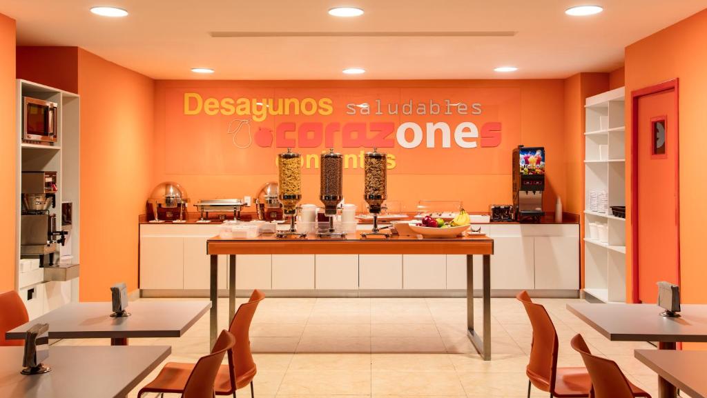 een restaurant met oranje muren en een tafel en stoelen bij One Irapuato in Irapuato