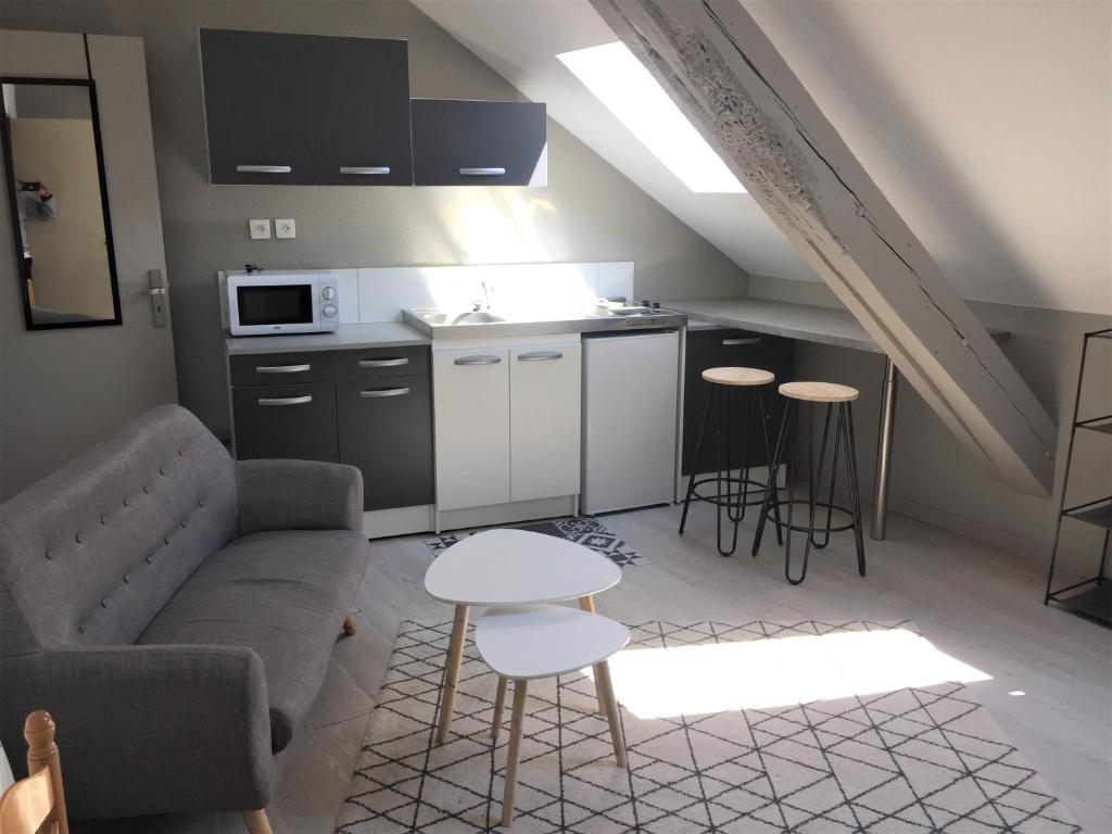 Il dispose d'une cuisine et d'un salon avec un canapé et une table. dans l'établissement Studio étage 3, proche Techn'hom, IUT et UTBM, à Belfort