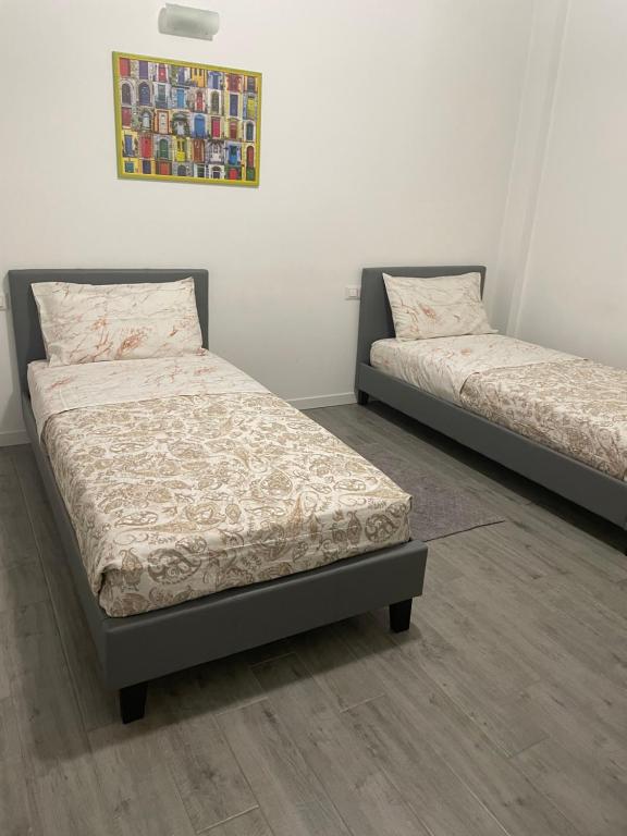 two beds sitting next to each other in a room at SweetHome in Lissone