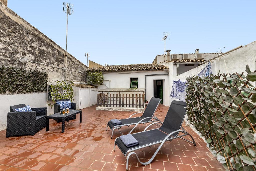 a patio with chairs and a table and a building at Flat in the old town of Alcudia in Alcudia