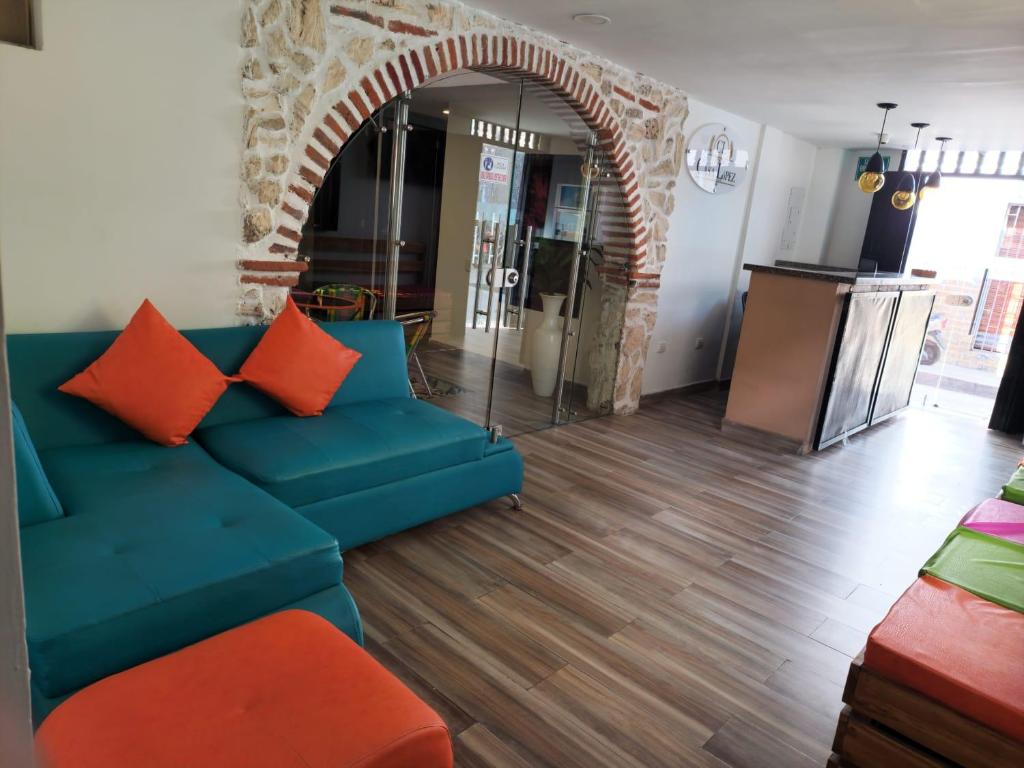 salon z niebieską kanapą z pomarańczowymi poduszkami w obiekcie Hotel CLG w mieście Cartagena de Indias
