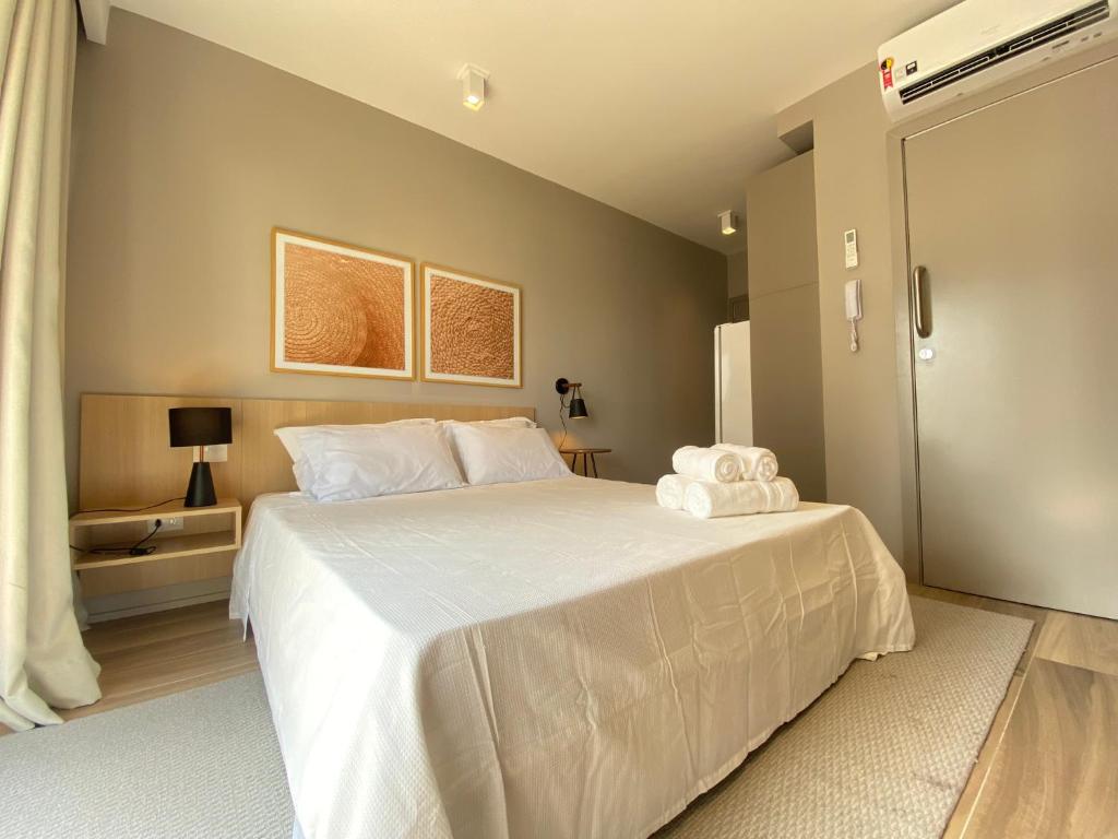 a bedroom with a large bed with white sheets at Studio Completo na Haddock Lobo in São Paulo