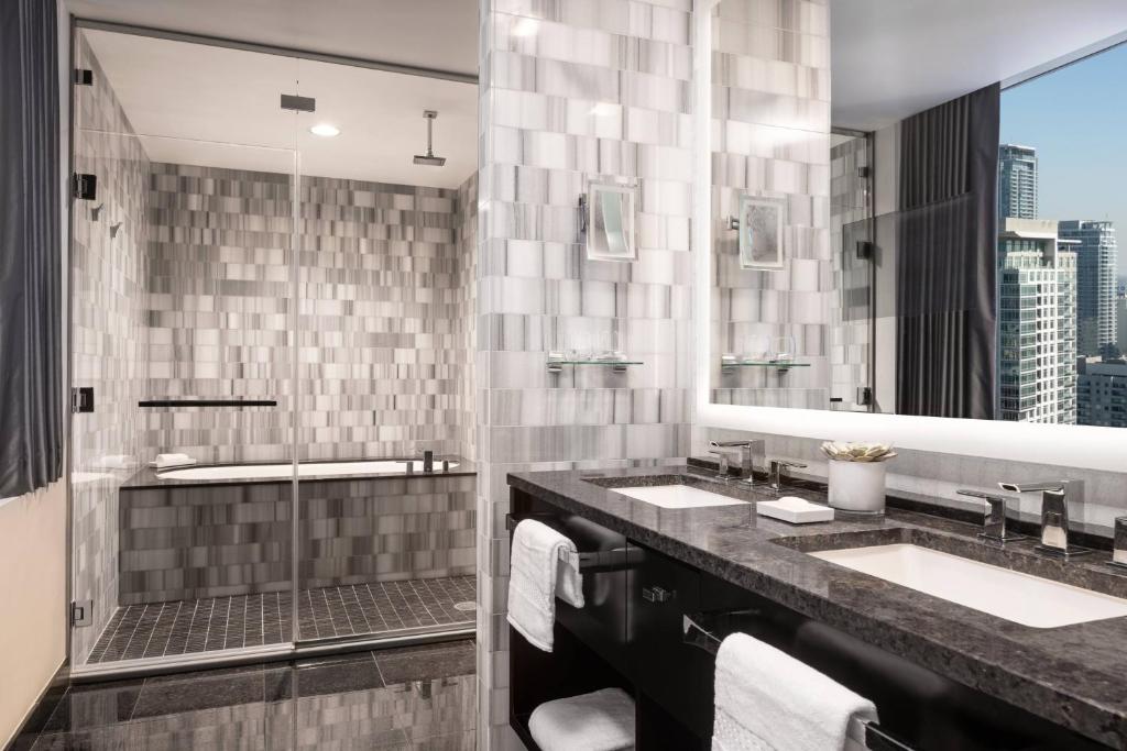 a bathroom with two sinks and a large mirror at The Ritz-Carlton, Los Angeles L.A. Live in Los Angeles