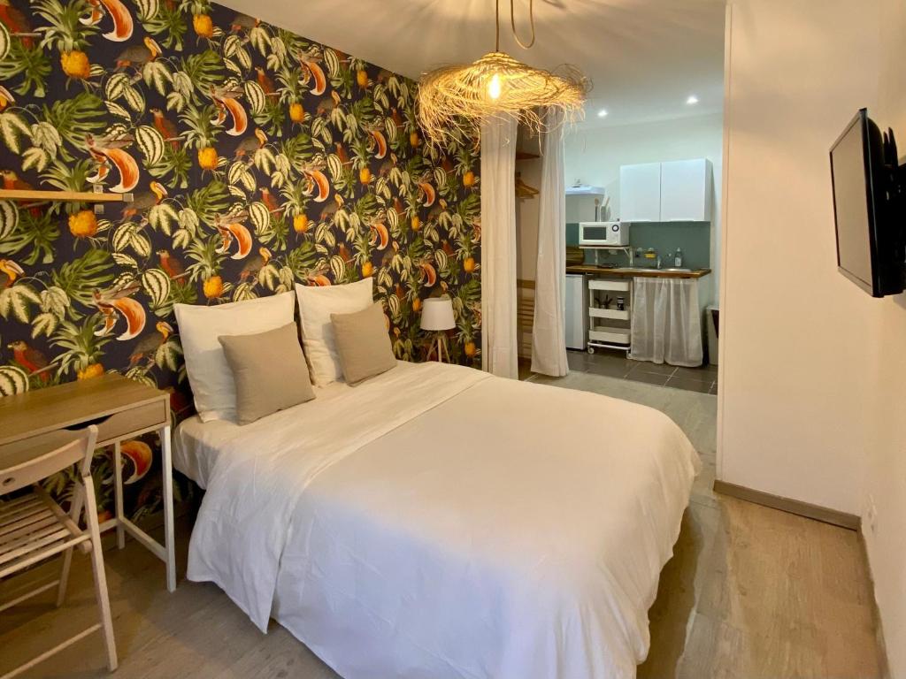 - une chambre avec un lit et un mur orné d'une fresque murale dans l'établissement Studio coeur de ville et au calme (1), à Montpellier