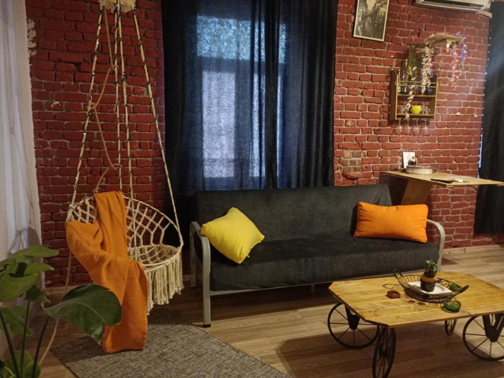 ein Wohnzimmer mit Sofa und Ziegelwand in der Unterkunft Taksim No:5 Suit in Istanbul