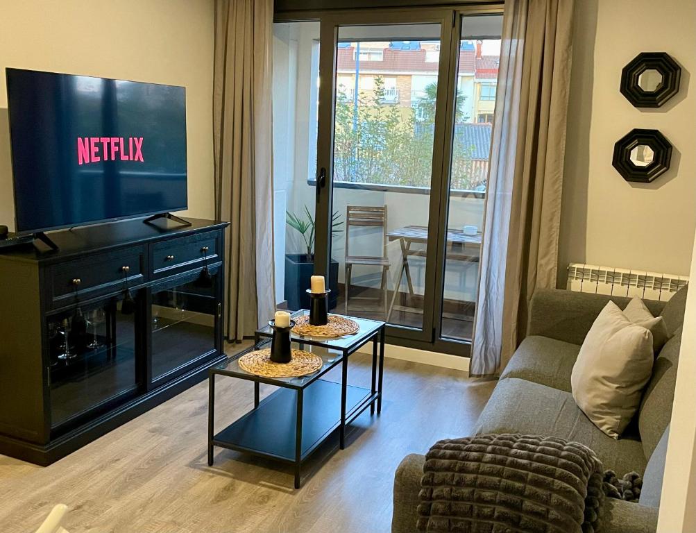 a living room with a couch and a television at Apartamento Entero 2 HABITACIONES in León