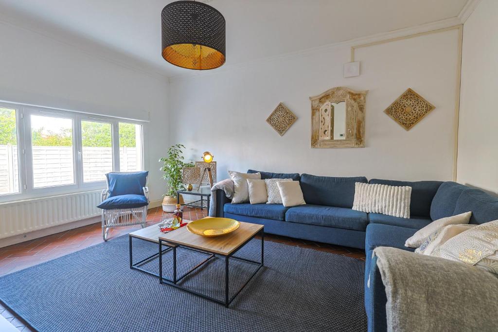 uma sala de estar com um sofá azul e uma mesa em Maison sur la route du Cognac em Saint-Même-les-Carrières