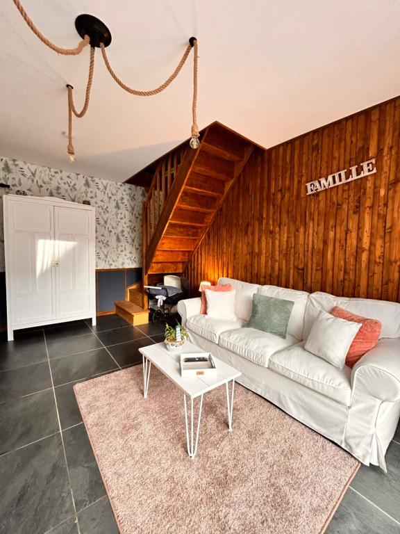 a living room with a white couch and a table at La Grange Aux Hirondelles - Chambre familiale in Woignarue