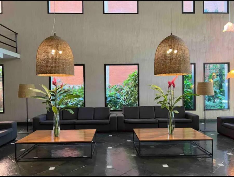 un soggiorno con divani, tavoli e finestre di Apartamento Copa Resort HIR 19 a Rio de Janeiro