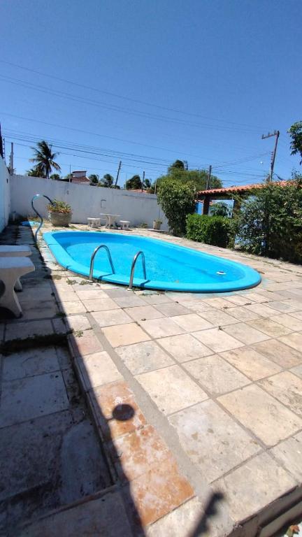 a large blue swimming pool in a yard at Suites na Praia do Francês in Marechal Deodoro