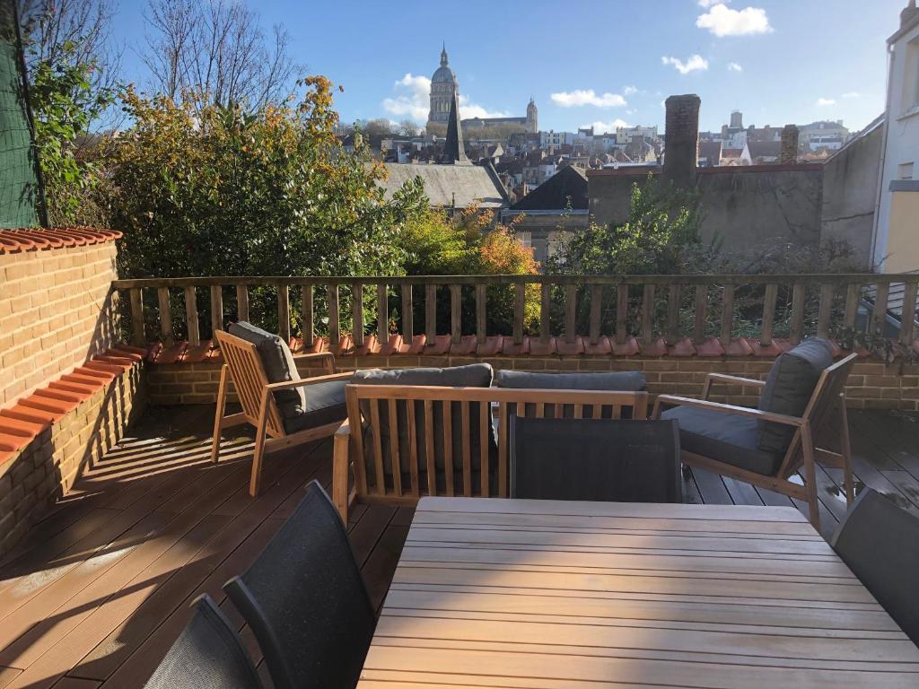 a wooden deck with chairs and a table on a balcony at Baudelocque in Boulogne-sur-Mer