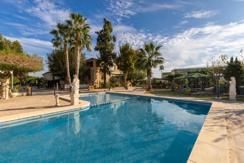 una gran piscina con palmeras y un edificio en Private Paradise Deluxe by Fidalsa, en Crevillente