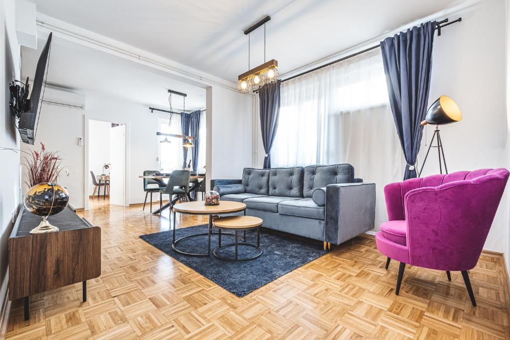 a living room with a couch and a purple chair at Colors Of Urban City - Zagreb in Zagreb