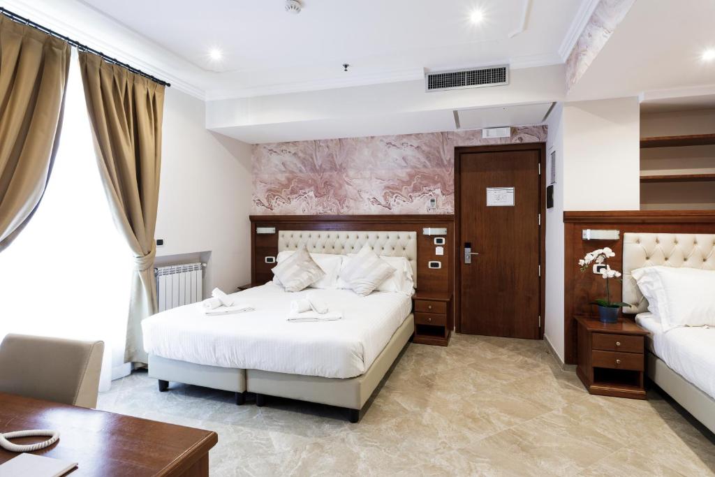 1 dormitorio con 2 camas, escritorio y mesa en Esposizione Luxury Rome en Roma