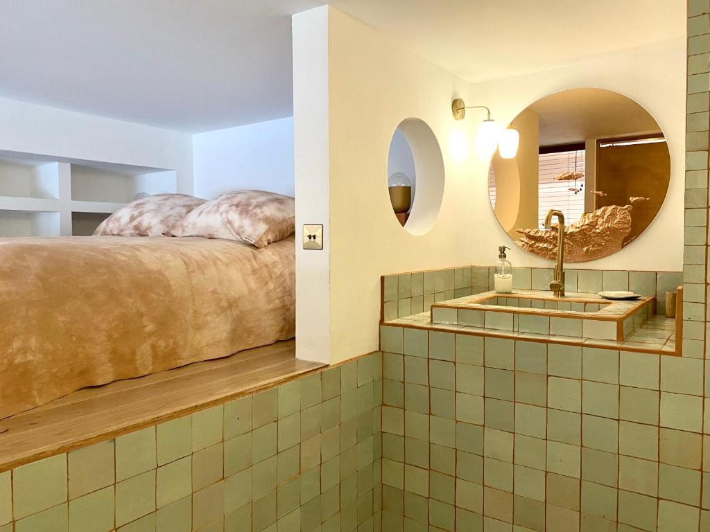 baño con cama y lavamanos en L'Annexe de la Madrague Marseille, en Marsella